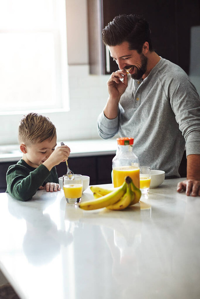 Jez. mladý chlapec a jeho otec snídají v kuchyni - Fotografie, Obrázek