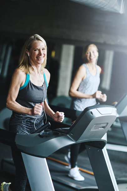 Correr es lo mejor para tu cuerpo. mujeres maduras haciendo ejercicio en el gimnasio - Foto, imagen