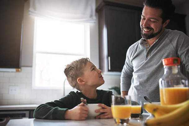 Köszi a reggelit, apa. egy kisfiú és az apja reggeliznek a konyhában. - Fotó, kép