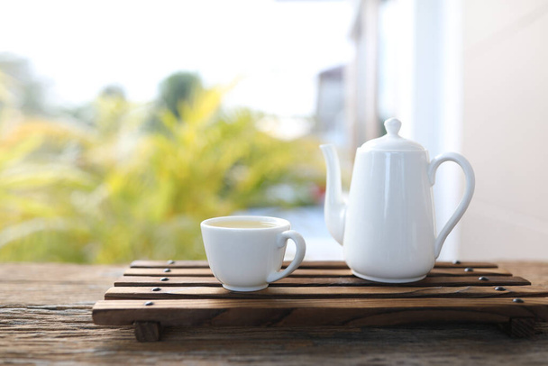 White tea pot and tea cup on tray wooden table - Foto, Imagen