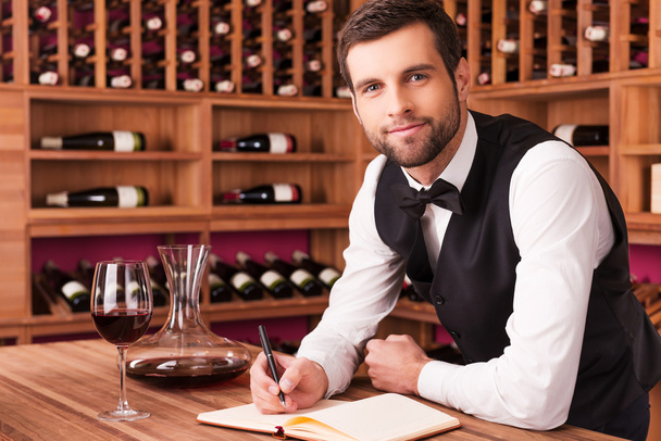 Sommelier writing in note pad - Photo, Image