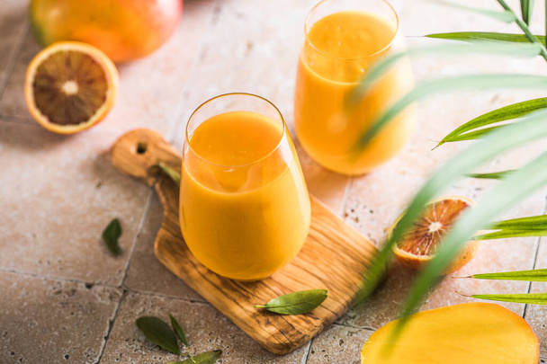 Two mango lassi or kesar milk in glasses. Indian healthy ayurvedic cold drink with mango. Freshness lassi made of yogurt, water, spices, fruits and ice. - Φωτογραφία, εικόνα