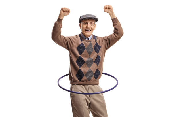 Happy elderly man spinning a hula hoop isolated on white background - Foto, imagen