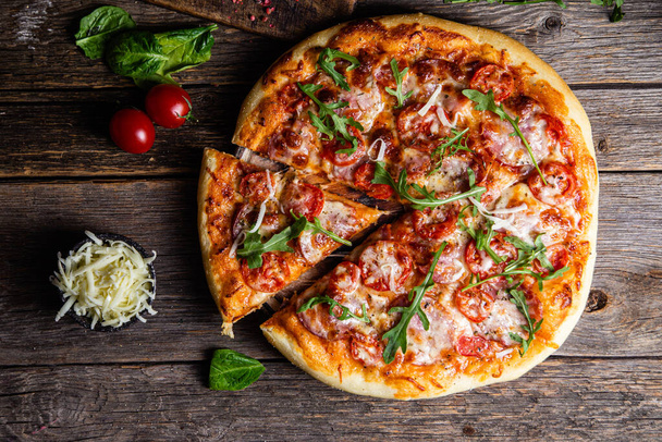 Pizza apetitosa com presunto em um fundo de madeira - Foto, Imagem