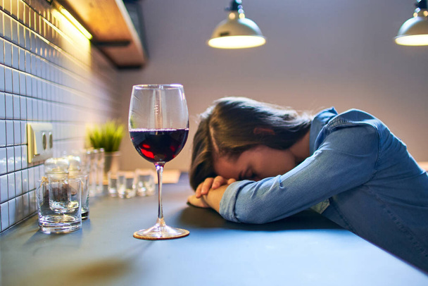 Lonely depressed drinking woman suffering from alcohol addiction abuse with red wine glass alone at home.              - Valokuva, kuva