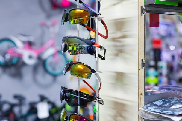 Una fila di occhiali da sole con sopra la parola occhiali da sole. Occhiali da sole in mostra in un negozio    - Foto, immagini