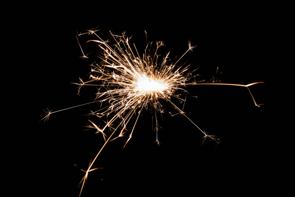 Burning sparkler isolated on black background. Fireworks theme. Light effect and texture. Christmas and new year decoration. - Foto, Bild