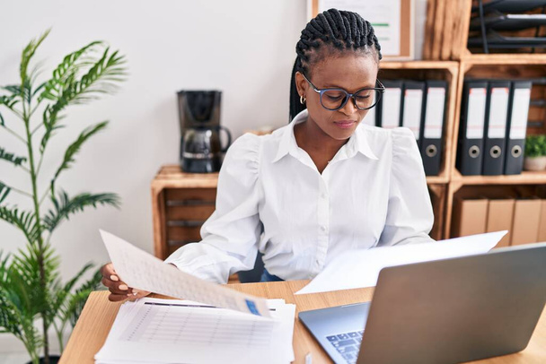 Afrikai-amerikai női üzleti dolgozó laptopolvasó dokumentumot használ az irodában - Fotó, kép