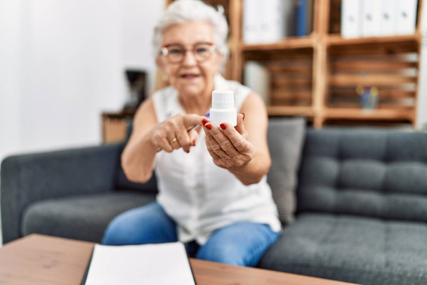 Senior grey-haired woman psychologist prescribing pills at psychology center - Foto, Imagen