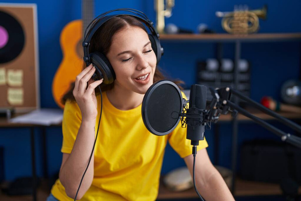 Young woman artist singing song at music studio - Foto, Imagen