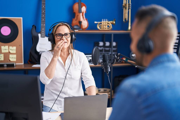 Man and woman musicians listening to music speaking at music studio - Foto, Imagem