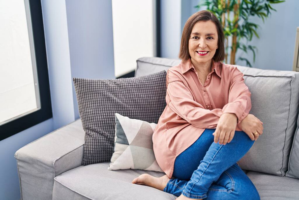 Middle age woman smiling confident sitting on sofa at home - Photo, Image