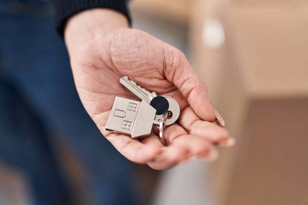 Young woman holding key standing at new home - Foto, Bild