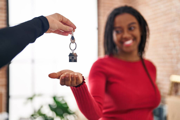 Африканская американка улыбается уверенно держа ключ в новом доме - Фото, изображение