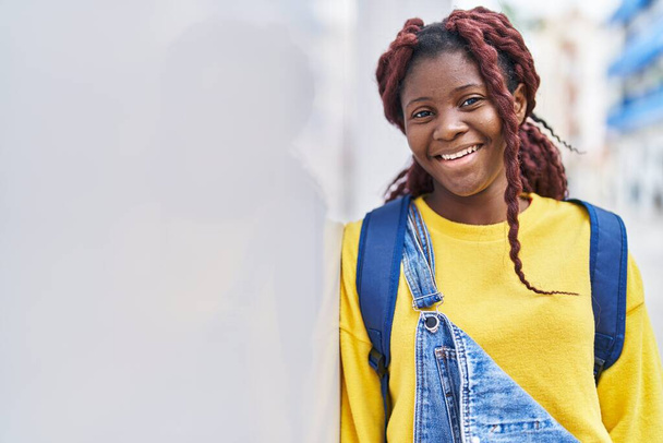 Африканська студентка - американка усміхається і впевнено вдягає рюкзак на вулиці. - Фото, зображення