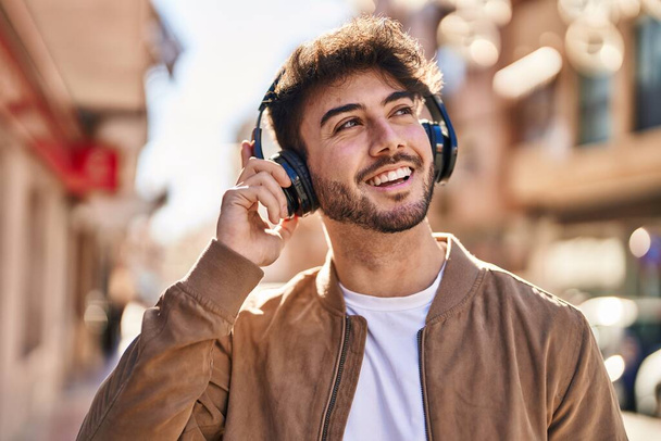 Young hispanic man smiling confident listening to music at street - Fotografie, Obrázek