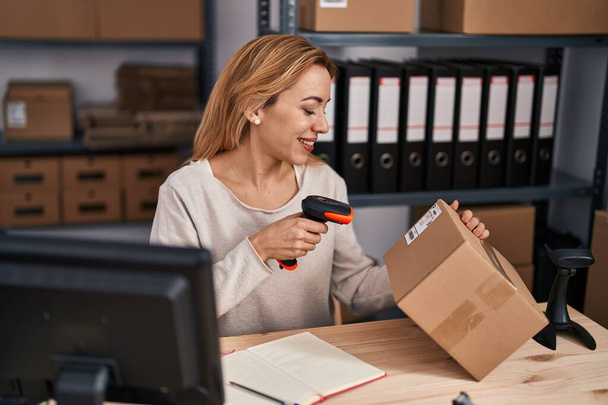 Young woman ecommerce busines worker scanning package at office - Foto, immagini