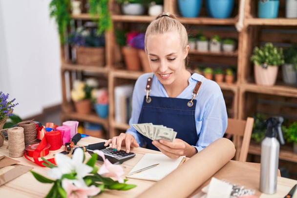Young blonde woman florist smiling confident counting dollars at florist - Fotoğraf, Görsel