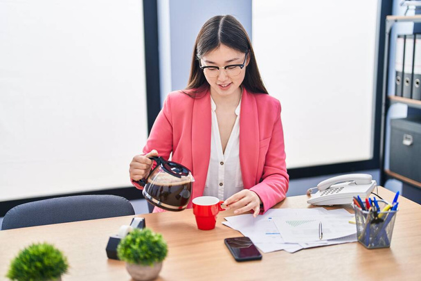 Chinese woman business worker pouring coffee on cup at office - Foto, Imagem