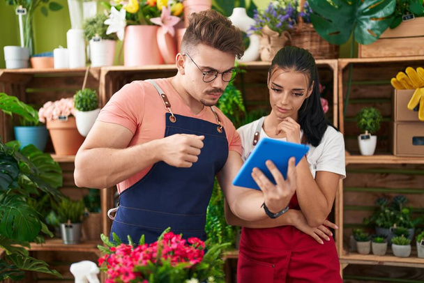 Чоловік і жінка флористи використовують тачпад, що працює в квітковому магазині
 - Фото, зображення