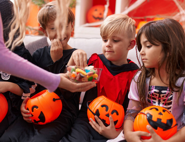 Groupe d'enfants portant un costume d'Halloween recevant des bonbons à la maison - Photo, image