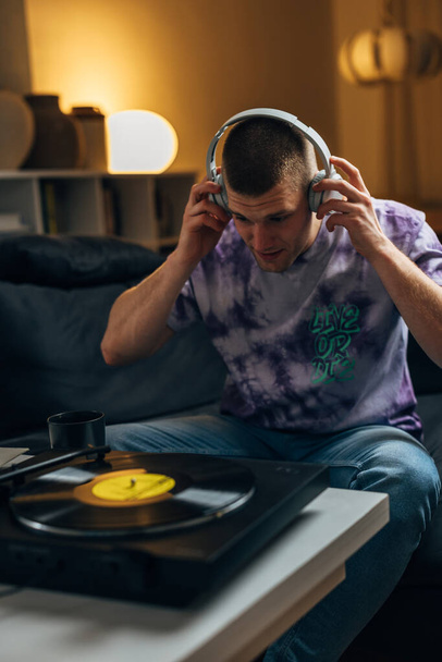 A Caucasian man puts on headset too listen to music - Фото, зображення