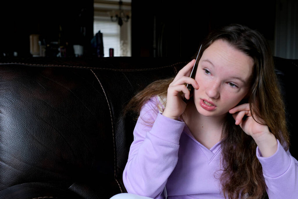 Zdenerwowana młoda kobieta siedzi w biurze rozmawiając przez telefon rozczarowany usłyszeć złe nowe smutne zamyślone dziewczyny pisząc notatki w notatniku czuje się nieszczęśliwy mówiąc o nieprzyjemnej rozmowie telefonicznej - Zdjęcie, obraz