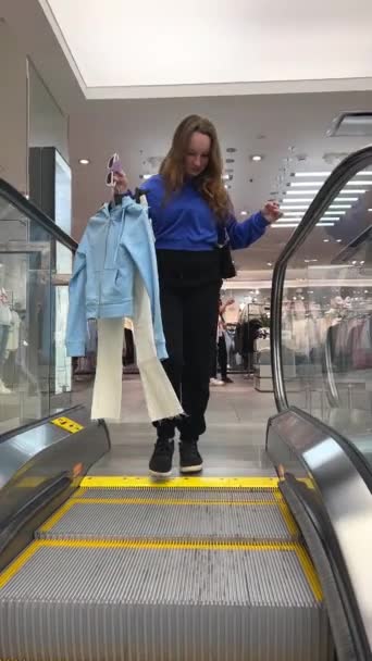 młoda nastolatka dziewczyna w garderobie taniec raduje patrząc na siebie w odbiciu w lustrze noszenie nowych ubrań sklep odzieżowy zakup aktualizacji zakupy nastolatki miłość ubrania radość zabawy w centrum handlowym - Materiał filmowy, wideo