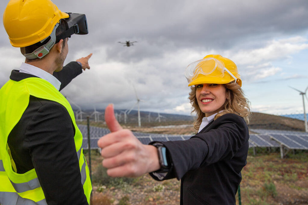 Two engineers during an inspection with drone and VR headsets in a solar farm, satisfied expression. - Photo, Image