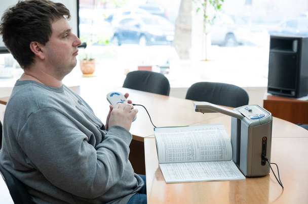 A visually impaired man uses a scanning and reading machine - Foto, Imagen