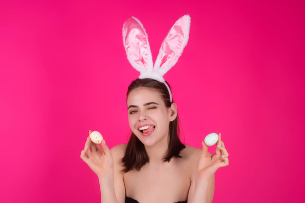 Close up photo of pretty girl wear easter fluffy bunny ears hold easter eggs, isolated studio background. Eater portrait of female bunny - Foto, afbeelding