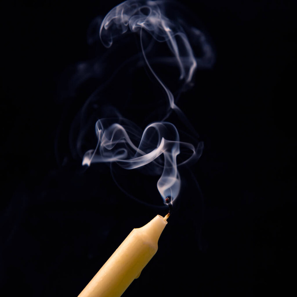 Smoke from an extinguished candle on a dark background. The concept of spirituality and the end of life. - Foto, Imagem