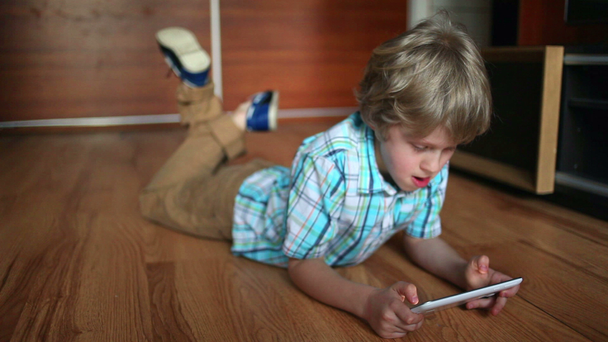 Dziecko przy użyciu komputera typu tablet. Chłopiec nastolatek za pomocą panelu dotykowego. Rozrywka z tabliczka Pc - Materiał filmowy, wideo