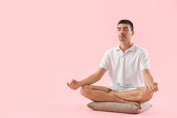 Young man meditating on pink background - Photo, Image