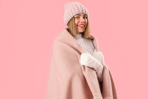 Frozen young woman in warm plaid on pink background - Фото, зображення