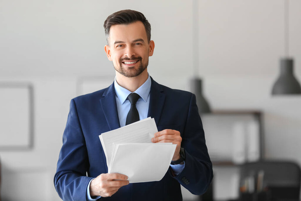 Handsome businessman with documents working in office - Photo, Image