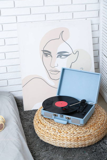 Gramofon z płytą winylową na puf w sypialni - Zdjęcie, obraz