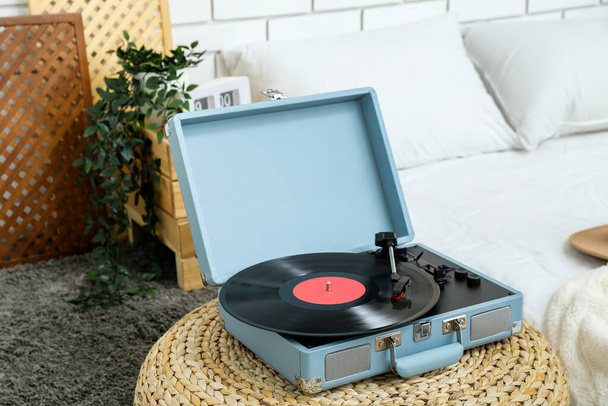Плеер Record с виниловым диском на pouf в спальне - Фото, изображение