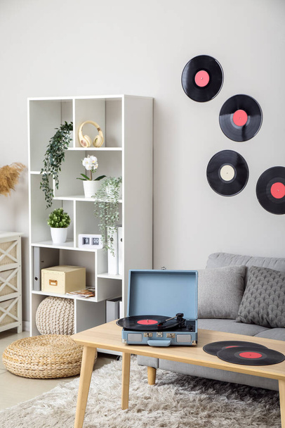 Record player with vinyl disks on table in interior of living room - Foto, Bild
