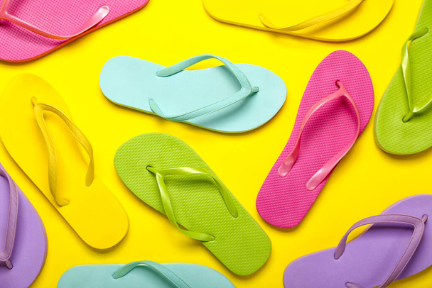 Colorful flip-flops on yellow background - Foto, imagen