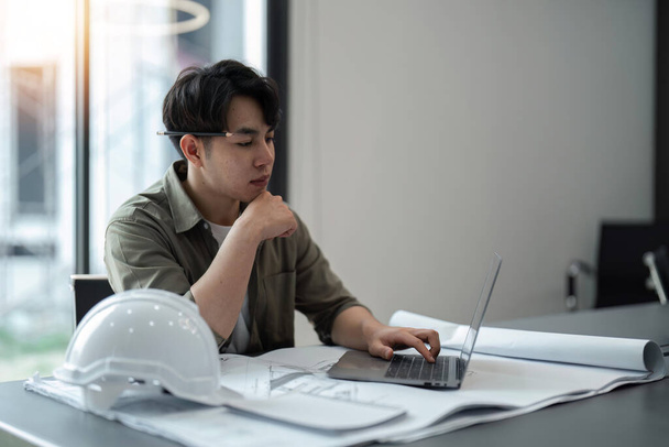 engineer man working with laptop and blueprints,engineer inspection in workplace for architectural plan,sketching a construction project ,Business concept vintage color. - Photo, Image