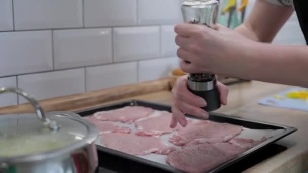 vrouw handen pepers geslagen vlees van hand pepermolen op huis keuken. voedselbereidingsproces - Video