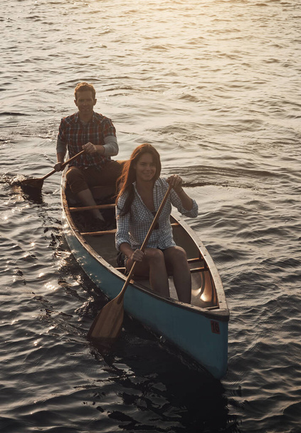 Adventurous activities is what we all about. a young couple rowing a boat out on the lake - Photo, Image