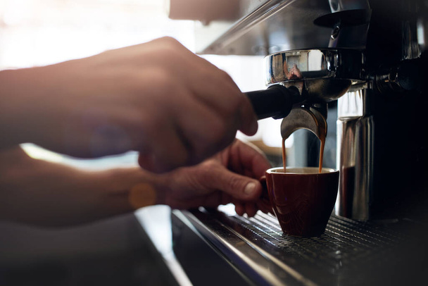 Una taza de felicidad, ahora mismo. Primer plano de un barista irreconocible operando una máquina de café en un café - Foto, Imagen