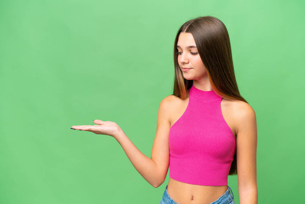 Teenager caucasian girl over isolated background holding copyspace with doubts - Φωτογραφία, εικόνα