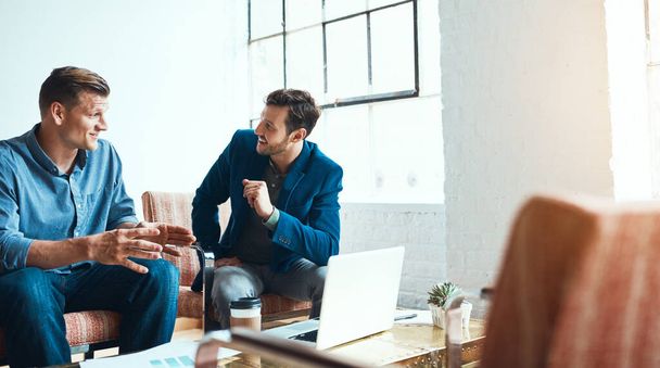 Os co-fundadores de uma startup online. dois jovens empresários tendo uma discussão e usando um laptop juntos em um escritório moderno - Foto, Imagem