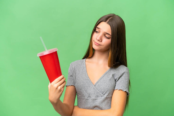 Teenager caucasian girl holding a soda over isolated background with sad expression - Foto, immagini