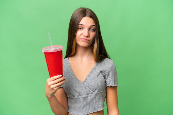 Teenager caucasian girl holding a soda over isolated background with sad expression - Photo, Image