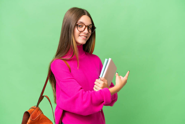 Teenager student caucasian girl over isolated background pointing back - Valokuva, kuva