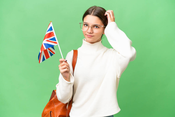 Неповнолітня студентка, яка тримає прапор Сполученого Королівства над ізольованим фоном має сумніви - Фото, зображення